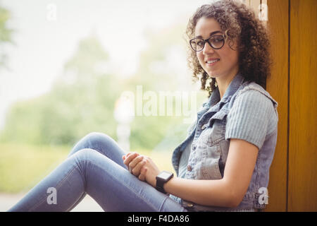 Hübsche Studentin Fenster in die Kamera Lächeln sitzen Stockfoto