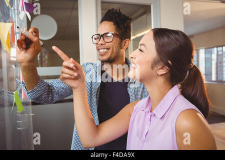 Geschäftsmann, während Kollege zeigte auf Kurznotizen schreiben Stockfoto