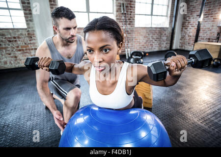 Persönlicher Trainer arbeiten mit Klienten mit Hantel Stockfoto