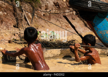 Zwei asiatische Jungs spielen im Schlamm Stockfoto