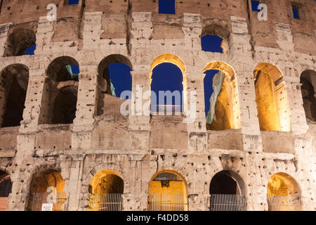 Detail der beleuchteten Bögen des Kolosseums in der Abenddämmerung. Rom, Italien Stockfoto