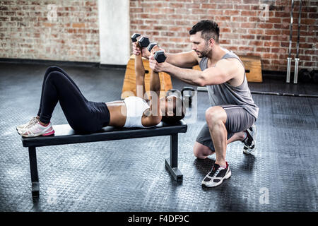 Persönlicher Trainer arbeiten mit Klienten mit Hantel Stockfoto