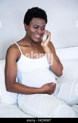 Schwangere Frau im Bett liegend Stockfoto