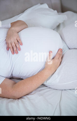 Schöne schwangere Frau ihren Bauch zu berühren Stockfoto