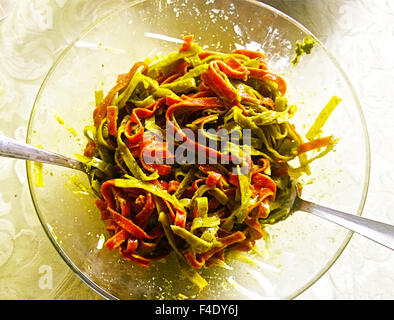 Italienische Nudeln grün und rot, gewürzt mit Spinat und Tomaten serviert mit Olivenöl und Parmesan Stockfoto