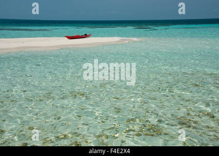 Belize, Belize. Goff Caye, beliebte Barrier Reef Insel direkt an der Küste von Belize City. Rote Kajak am weißen Sandstrand (großformatige Größen erhältlich). Stockfoto