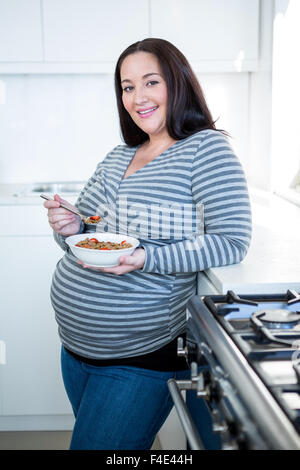 Lächelnde schwangere Frau frühstücken Stockfoto