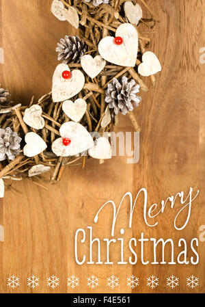 Frohe Weihnachtsbotschaft, handgemachte Kranz Dekoration Shabby Chic white Holzherzen mit roten Beeren über hölzerne Hintergrund - re Stockfoto