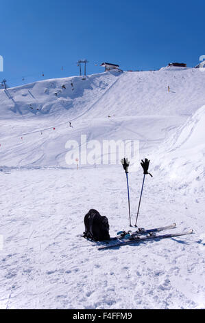 Ein paar Ski, Skistöcke mit Handschuhen und einem Rucksack in der Nähe von Skipisten und Liftanlagen im Skigebiet Sölden in Österreichische Alpen Stockfoto