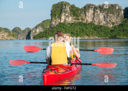 Paare Kajak durch die Gewässer der Bai TU Long Bay in Halong Bay, ein UNESCO-Weltkulturerbe in Vietnam, Asien Stockfoto