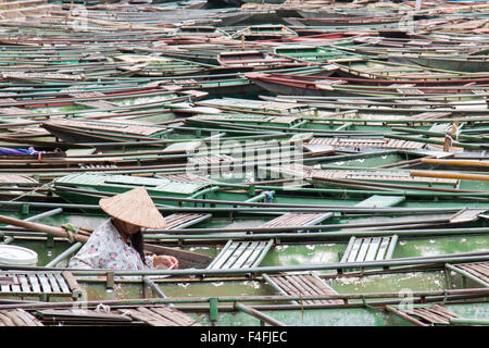 vietnamesische Dame touristischen Ruderboote erwarten Kunden bei Tam Coc Ngo Dong Flusshafen, Ninh Binh, Nord-vietnam Stockfoto