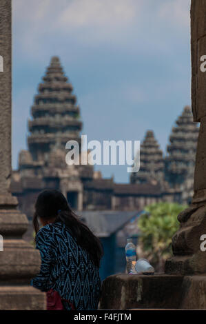 Mädchen von hinten sitzen vor Angkor Wat Stockfoto