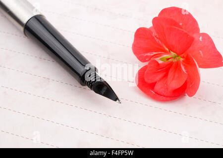 Notizbuch, Stift und Blume Stockfoto