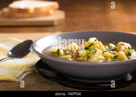 Kartoffelsuppe in graue Schale mit Löffel und Brot Stockfoto