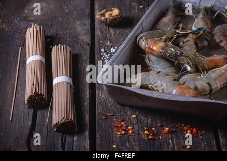 Zutaten für asiatische Abendessen ungekocht Soba-Nudeln, eingeweichten Shiitake-Pilzen und Garnelen über alten hölzernen Hintergrund mit Salz ein Stockfoto