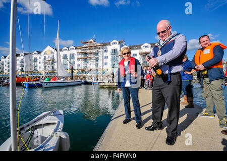 Carrickfergus, Nordirland. 17. Oktober 2015 - der Bürgermeister von Carrickfergus, Billy Ashe, öffnet eine Flasche Champagner, Name einer der drei neuen Boote für Belfast Lough Sailability, eine Wohltätigkeitsorganisation, die lehrt, behinderten Kindern wie Segeln. Bildnachweis: Stephen Barnes/Alamy Live-Nachrichten Stockfoto