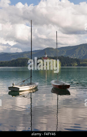 Kleine Yachten vor Anker am Bleder See vor der Insel mit der Kirche Mariä Himmelfahrt, Slowenien. Stockfoto