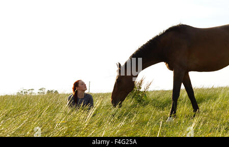 Emily und ihr Pferd füttern und Beweidung Stockfoto