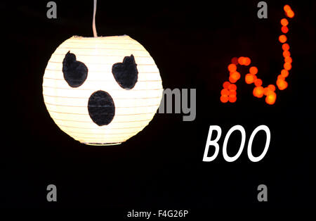 Halloweendekoration und Festschmuck.  Weiß glühenden Geist, Kürbis-Gesicht mit schwarzem Hintergrund.  Orange leuchtende Lichter und BOO angezeigt. Stockfoto
