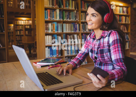 Studentin Musik hören während mit laptop Stockfoto