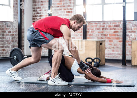 Fit Woman tun einige stretching mit ihrem trainer Stockfoto