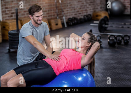 Trainer unterstützen Frau mit Bauch-crunches Stockfoto