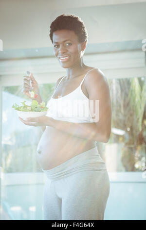 Porträt von lächelnden schwangere Frau mit Salat Stockfoto