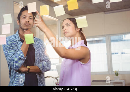 Geschäftsfrau zeigt auf Haftnotizen Stockfoto