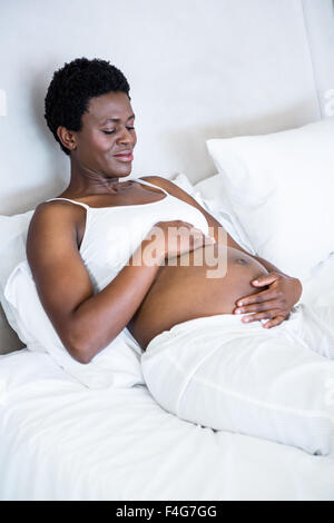 Schwangere Frau sitzen im Bett Stockfoto