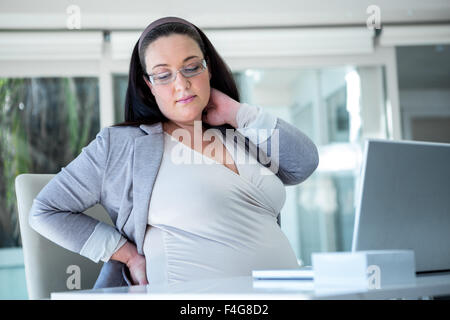 Porträt von schwangeren Geschäftsfrau an ihrem Schreibtisch Stockfoto