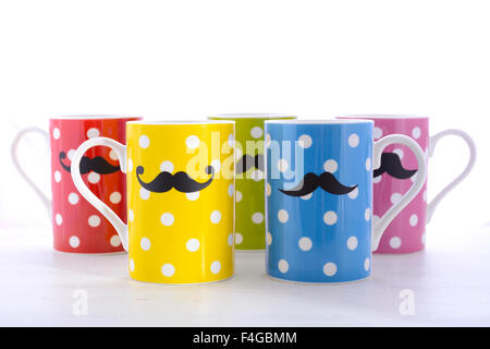 Bunte Polka Dot Kaffee Tassen mit Schnurrbärte für November Mens Gesundheitsbewusstsein auf weißer Holztisch. Stockfoto