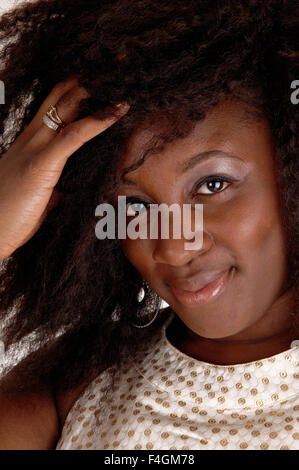 Eine schöne Nahaufnahme Portrait Bild einer afroamerikanische Frau, lächelnd in einem beigen Kleid für weißen Hintergrund isoliert. Stockfoto