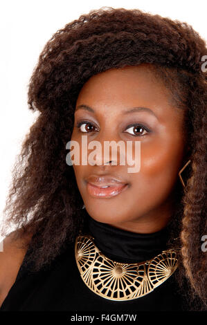 Ein Kopf schießen einer jungen afroamerikanischen Frau in einem schwarzen Kleid, mit Goldkette und krauses Haar, isoliert auf weiss Stockfoto