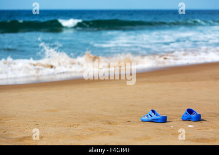 Blaue Damenschlappen am Meer Sandstrand, Sommer Urlaub Konzept Stockfoto