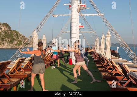 Dawn Tai Chi Lektion auf dem Deck des Drachen, eine Legende in Bai Tu long, Halong Bucht, Vietnam Stockfoto