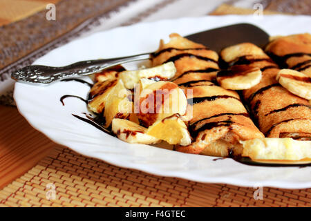 Pfannkuchen gefüllt mit Grieß, Bananen und Orangen getränkt dunklen Schokolade Stockfoto