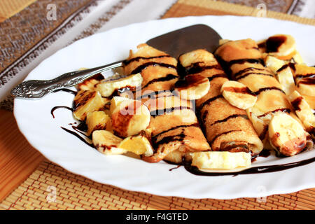 Pfannkuchen gefüllt mit Grieß, Bananen und Orangen getränkt dunklen Schokolade Stockfoto