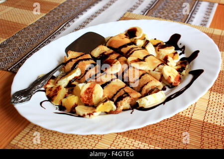 Pfannkuchen gefüllt mit Grieß, Bananen und Orangen getränkt dunklen Schokolade Stockfoto