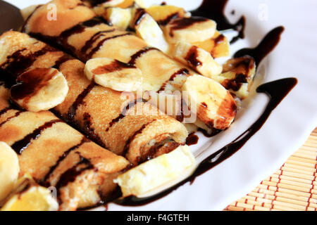 Pfannkuchen gefüllt mit Grieß, Bananen und Orangen getränkt dunklen Schokolade Stockfoto