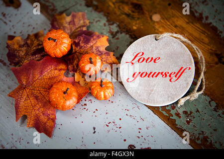 "Liebe dich selbst" auf hölzernen Schild auf alten Vintage Tisch mit Kürbisse und Blätter Stockfoto