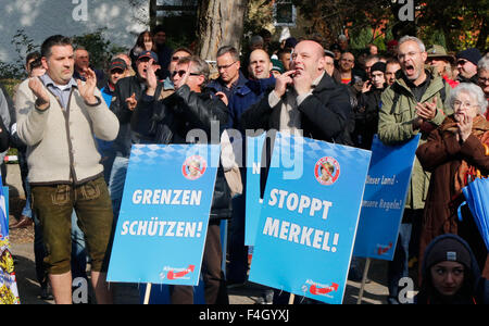 Freilassing, Deutschland. 17. Oktober 2015. Demonstranten halten Schilder mit der Aufschrift "Grenzen Schuetzen!" (schützen) und "Stoppt Merkel!" (Haltestelle Merkel) bei einer Demonstration in Freilassing, Deutschland, 17. Oktober 2015. Rund 1000 Menschen, angeführt von der rechtspopulistischen Alternative Fuer Deutschland (AfD) Partei, gegen die Bundesregierung Asylpolitik protestiert. Es gab eine Gegendemonstration von rund 600 Personen zur gleichen Zeit am Samstag. Foto: AKTIVNEWS/DPA/Alamy Live-Nachrichten Stockfoto