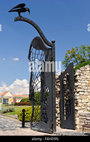 Eine Skulptur von einem schwarzen Raben mit einem Ring im Schnabel auf einem Metalltor, Budapest, Ungarn. Stockfoto