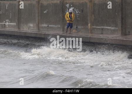 Navotas City, Philippinen. 18. Oktober 2015. Ein Mann geht auf einem Wellenbrecher der Manilabucht bei starkem Wind von Typhoon Koppu in Navotas Stadt, den Philippinen, 18. Oktober 2015. Taifun-Koppu, lokal namens Lando, bildete Landfall in Manila, Aurora Provinz des nordöstlichen Philippinen um ca. 01:00 Sonntag, die lokale Katastrophe Verringerung der Behörde sagte. © Rouelle Umali/Xinhua/Alamy Live-Nachrichten Stockfoto