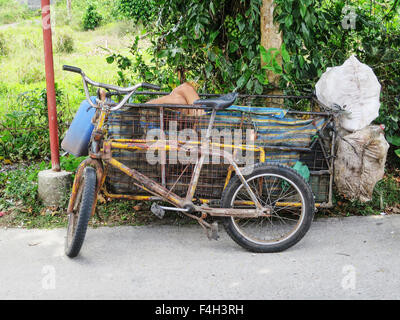 Ein Filipino Mann nimmt eine Siesta am Nachmittag von seiner Arbeit sammeln Flaschen in den Beiwagen seines Fahrrades. Stockfoto