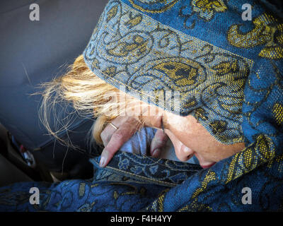Nahaufnahme einer schlafenden Frau in einem blauen Schal. Stockfoto