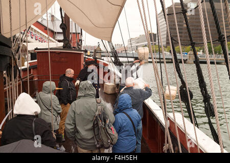 Touristen, die Tee-Schatullen in ein Re-Enactment über Bord zu werfen; Die Boston Tea Party Schiffe und Museum, Boston Massachusetts, USA Stockfoto