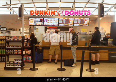 Menschen in einer Warteschlange bei Dunkin Donuts-Fastfood-Restaurant, das Terminal, Flughafen Boston, USA Stockfoto