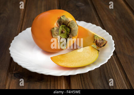 Frische natürliche Kaki Früchte auf Holztisch Stockfoto