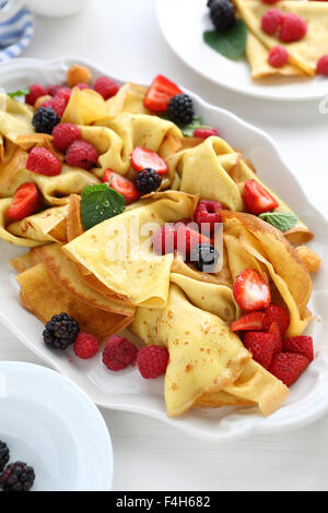 Crepes mit frischen Beeren heiß essen Stockfoto