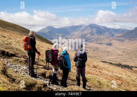 Vier Wanderer Blick in Blick auf Mount Snowdon Horseshoe bei Wanderungen auf dem Weg von der MOEL zu Capel Curig Siabod in Berge von Snowdonia (Eryri) Wales UK. Stockfoto